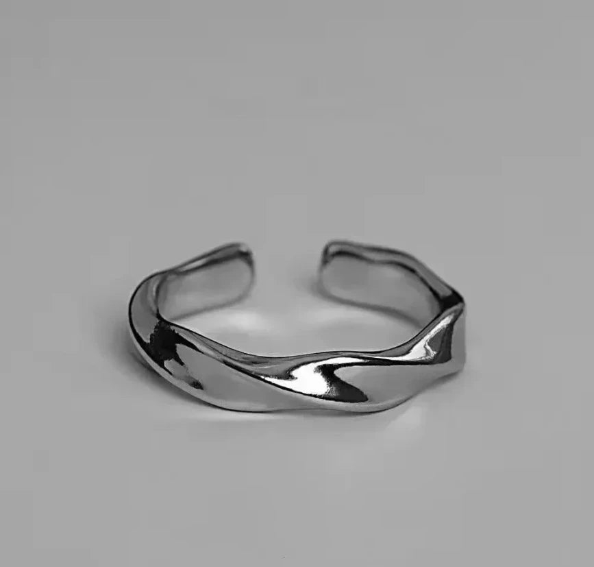 A small, niche, high-end Instagram-worthy ring in a minimalist, cool-toned, high-fashion style for both men and women.